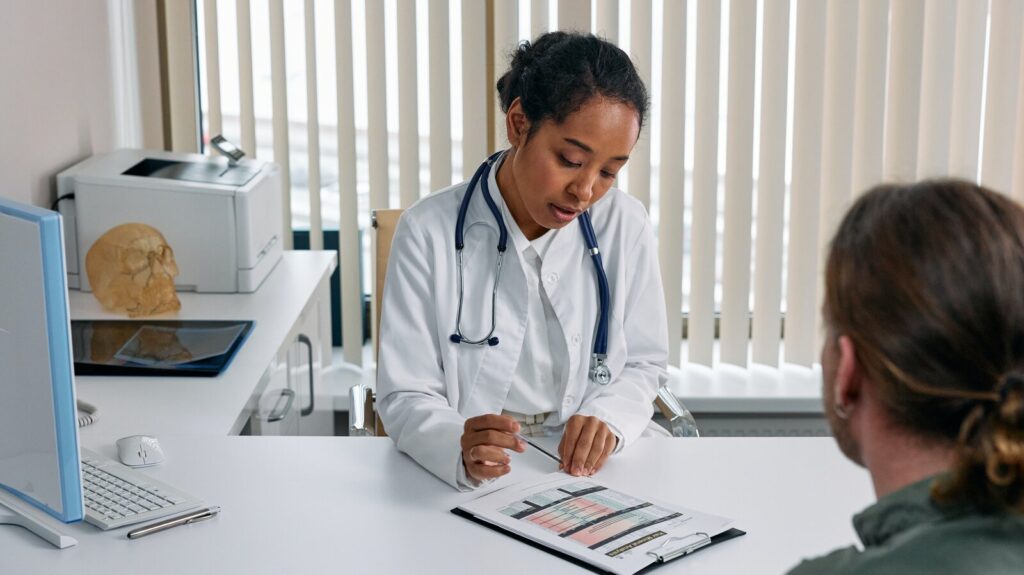 Physician reviewing the results of her patient's genetic test results with him in her office